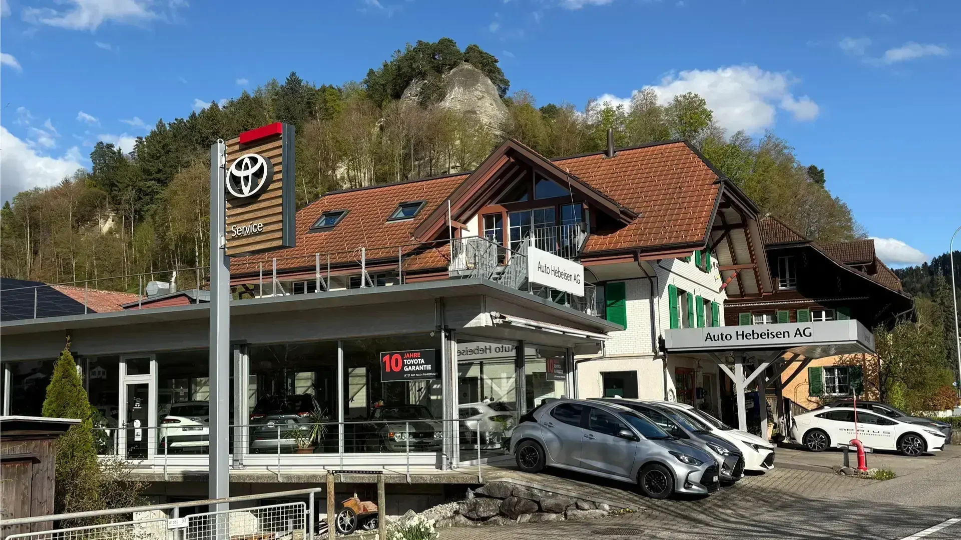 Aktueller Toyota Showroom und Servicebetrieb der Auto Hebeisen AG in Krauchthal mit Hybrid- und Neuwagen vor dem Gebäude.