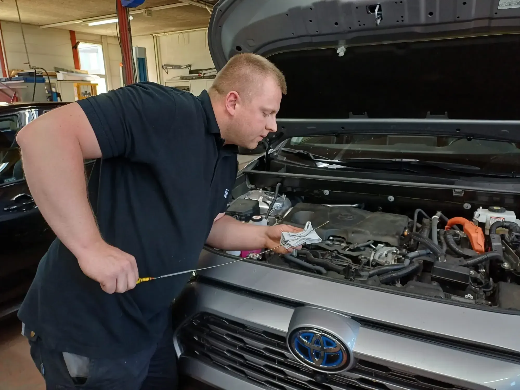 Toyota Mechaniker bei der Fahrzeugwartung in der Werkstatt – fachgerechter Service für Toyota Fahrzeuge bei Auto Hebeisen AG.